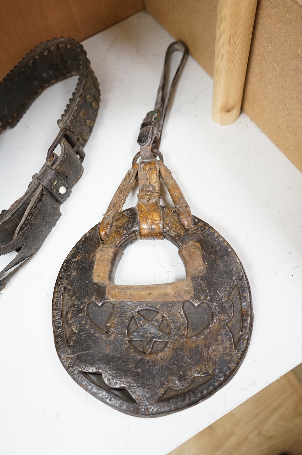 A pair of Argentinian Gaucho leather and piqué work stirrups together with a similar brass mounted belt